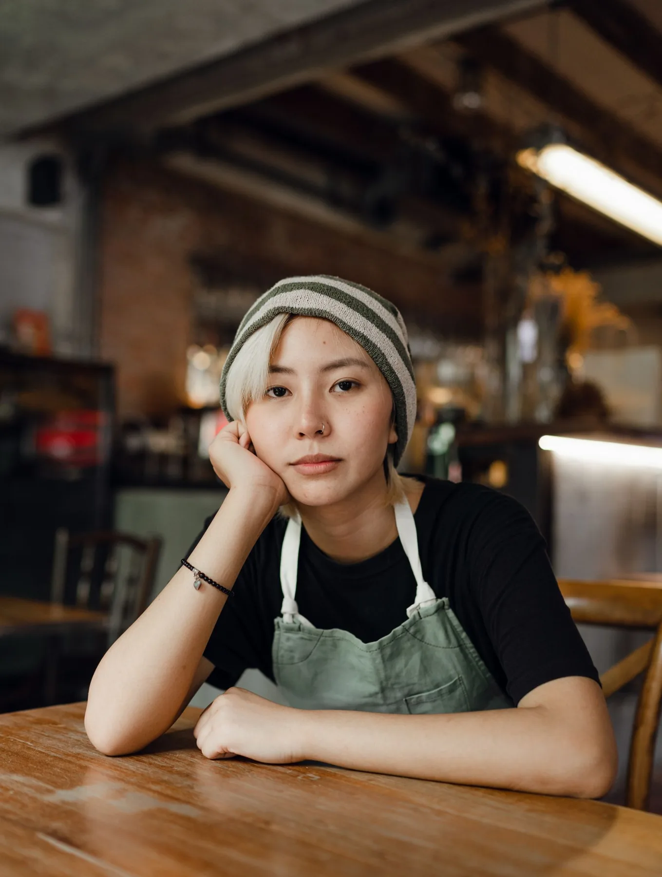 앞치마를 입고 아침 매장 테이블에 앉은 사람
